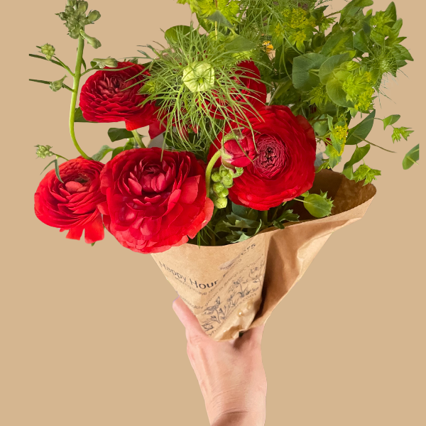 A beautiful bouquet featuring La Belle Ranunculus Chocolate blooms, hand-held prominently, crafted by The Happy Hour Flowers, perfect for adding charm to any cutting garden or wedding. Arlington, red, plant, cut flower, cutting garden, La Belle Ranunculus Chocolate corms for sale farmer, florist, floral.