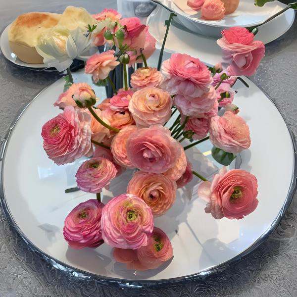 a white plate topped with pink flowers on top of a table